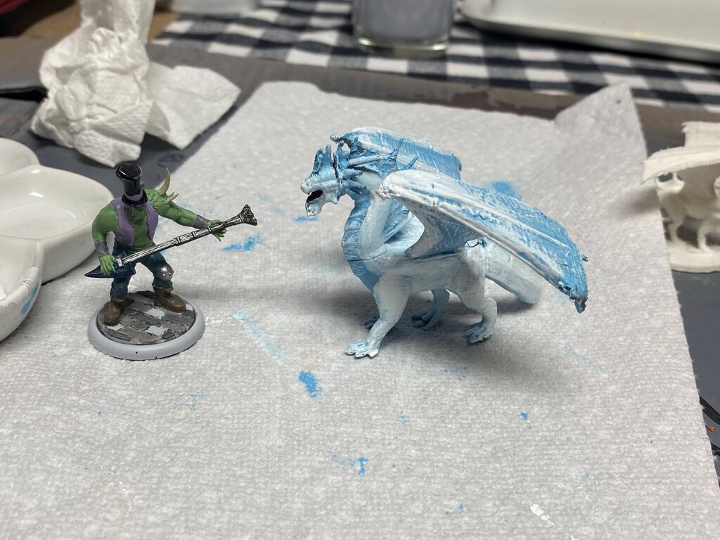 A Malifaux mini Kasul was painting, and the white dragon midway from blue